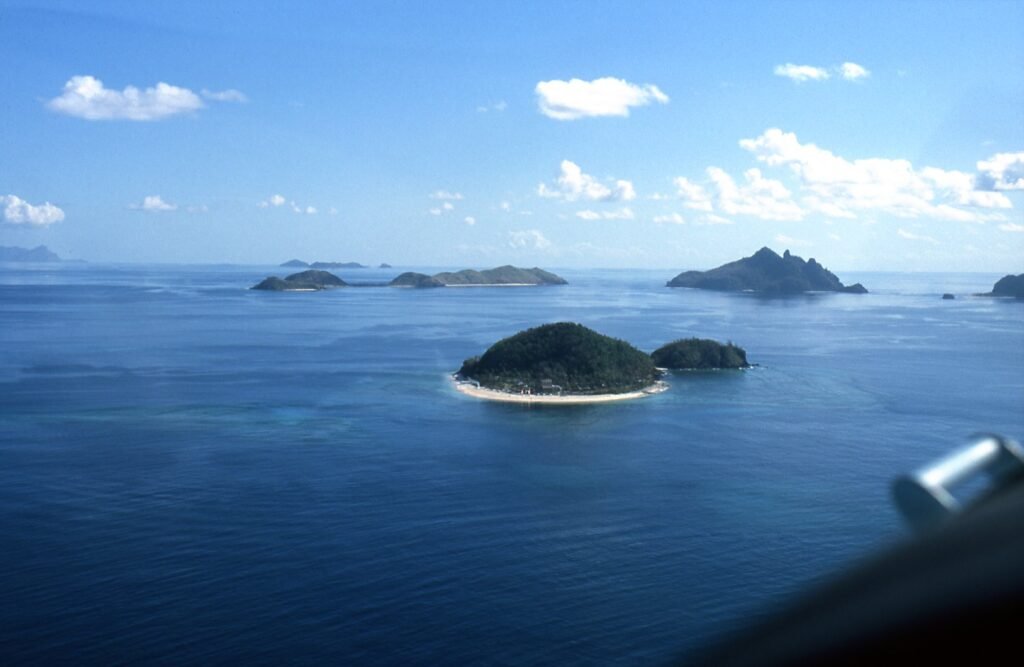 Small reef-fringed islands of the Mamanuca group seen from a plane over the Pacific Ocean