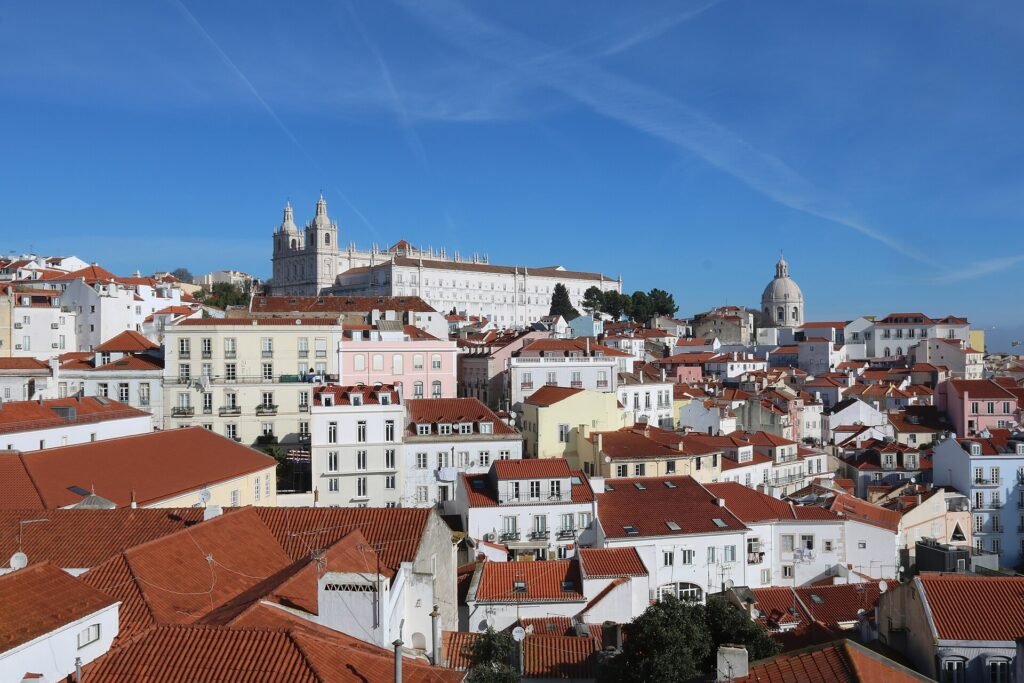 Rooftops of the Alfama district in Lisbon seen from the Santa Luzia viewpoint, with the Sao Vicente de Fora monastery and the dome of Santa Engracia