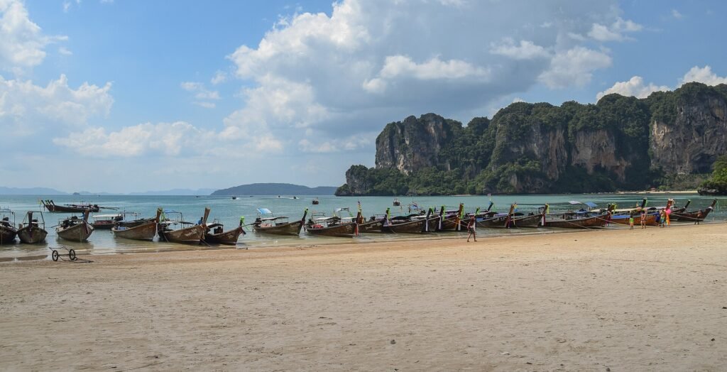 Bateaux à longue queue sur la plage de West Railay, à Krabi, devant les falaises calcaires