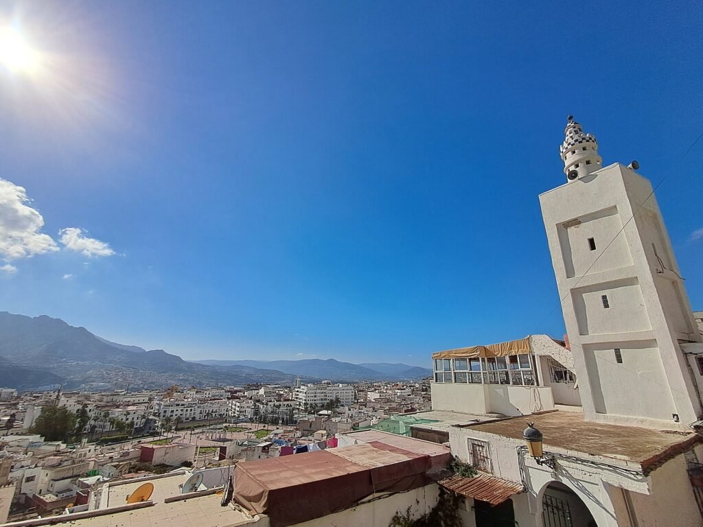 White rooftops and a minaret in the Tetouan medina with the Rif mountains behind