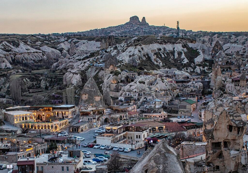 Le village de Göreme en Cappadoce, entre les cônes de tuf, avec le rocher d'Uçhisar à l'horizon
