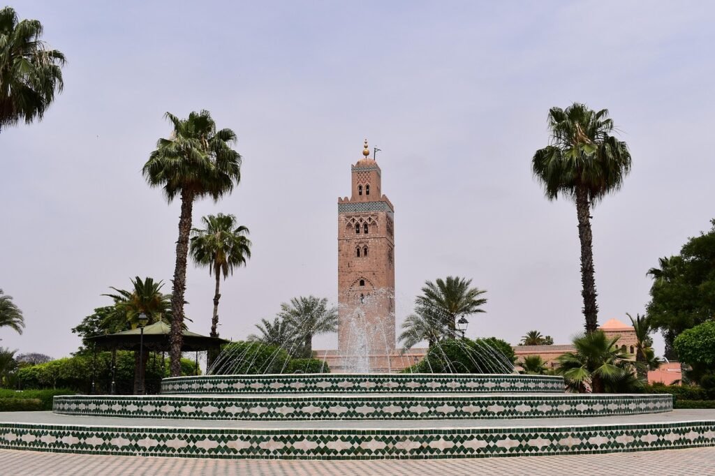 Le minaret de la Koutoubia à Marrakech, vu depuis une fontaine entourée de palmiers
